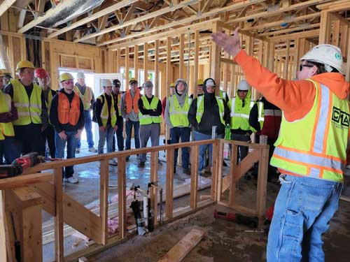 Brian Steinhoff shows students different parts of the construction process including rough framing and plumbing.