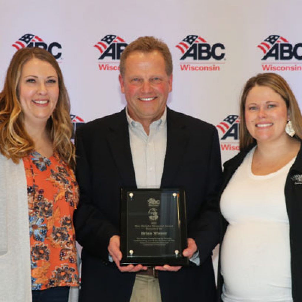 Photo of Brian Wieser, his daughters and the Wes Meilahn Award.